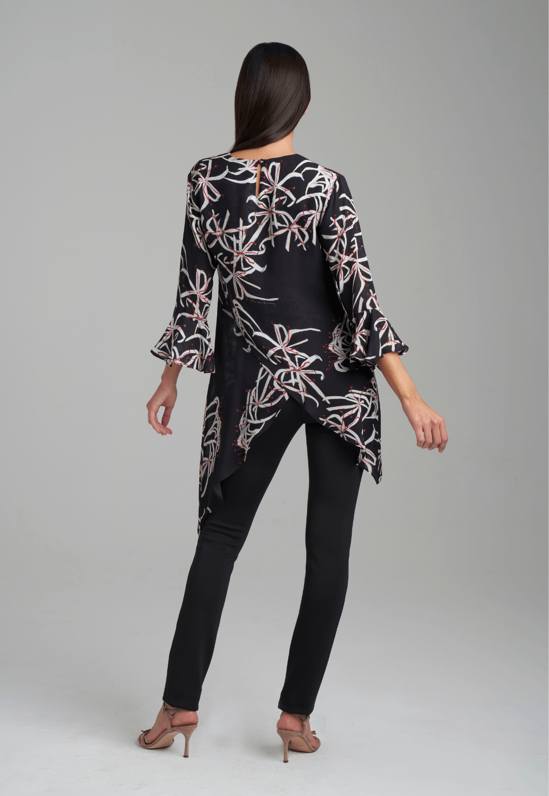Woman wearing assymetrical black spider lily silk blouse by Ala von Auersperg for holiday 2021
