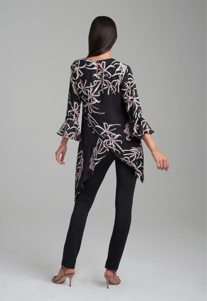Woman wearing assymetrical black spider lily silk blouse by Ala von Auersperg for holiday 2021