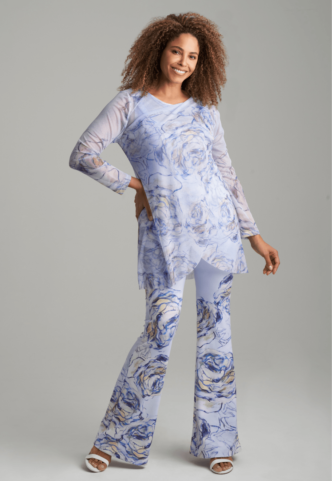 Woman wearing blue rose printed mesh tunic over blue rose printed stretch knit tank top and pants by Ala von Auersperg for spring summer 2022