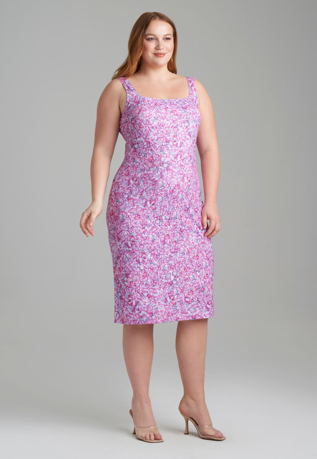 Woman wearing stretch knit pink printed orchid flowers short dress by Ala von Auersperg for resort 2022