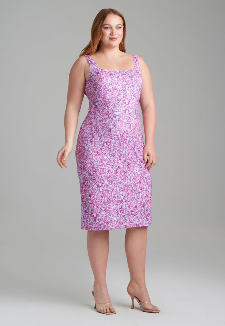 Woman wearing stretch knit pink printed orchid flowers short dress by Ala von Auersperg for resort 2022
