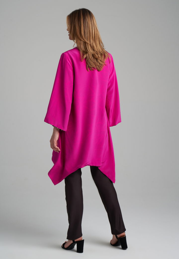 Woman wearing silk black spider lily printed reversible pink robe jacket over black stretch knit tank top and pant by Ala von Auersperg