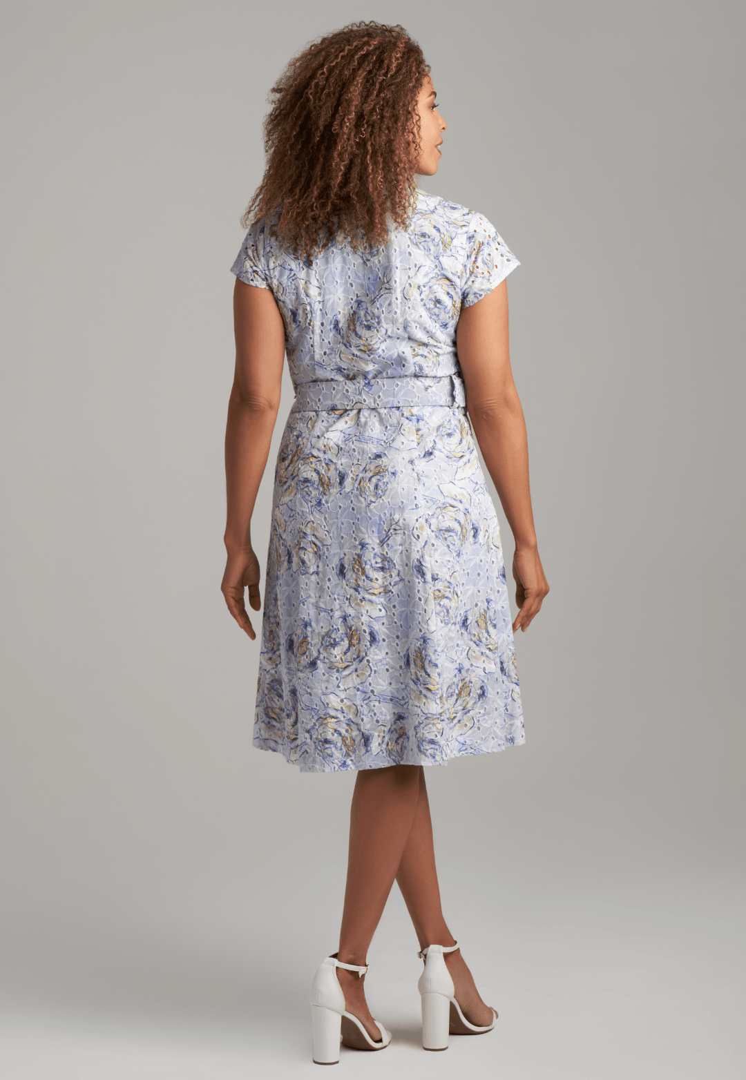 Woman wearing blue rose printed cotton eyelet short dress with belt by Ala von Auersperg for spring summer 2022