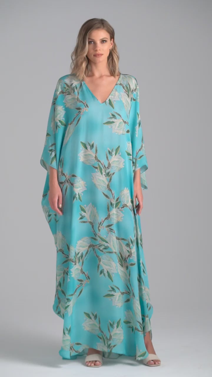 Woman wearing blue silk yucca printed long kaftan with v neck by Ala von Auersperg for spring 2023