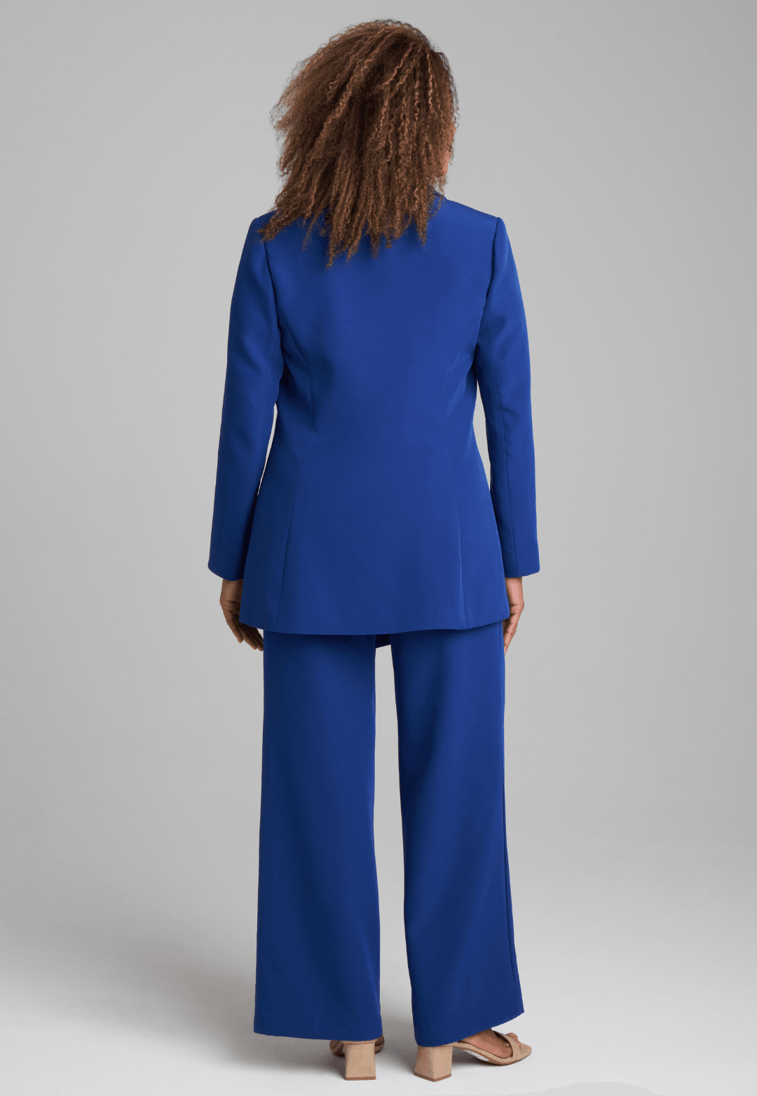 Woman wearing silk lined sapphire blazer with printed silk shell tank top and stretch blue pants suite by Ala von Auersperg for fall 2022
