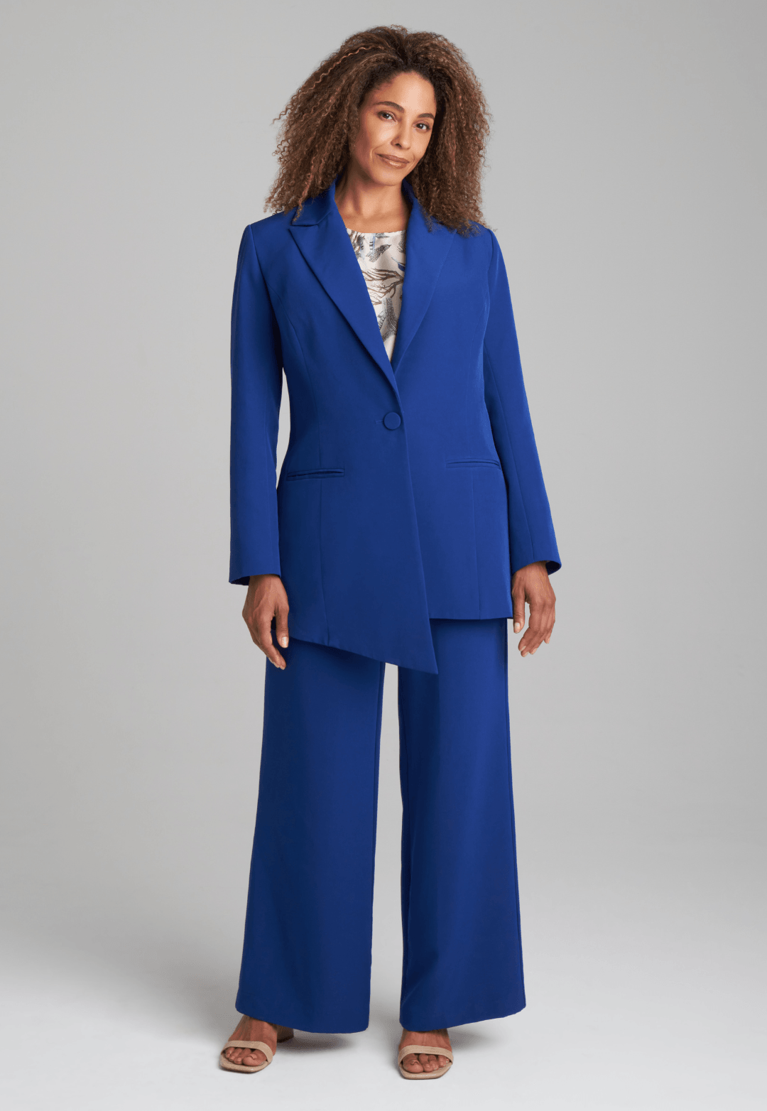 Woman wearing silk lined sapphire blazer with printed silk shell tank top and stretch blue pants suite by Ala von Auersperg for fall 2022