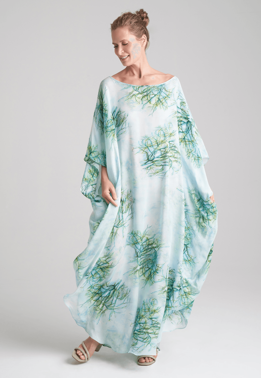 Woman wearing silk boat neck green printed kaftan by Ala von Auersperg