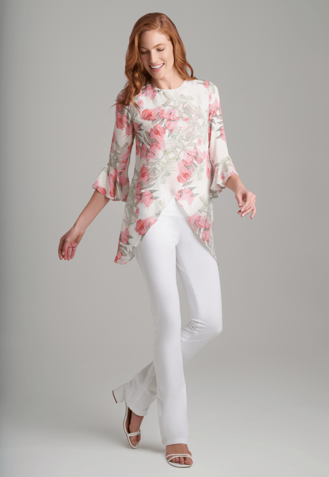Woman wearing silk asymmetrical flower printed blouse with stretch knit white pants by Ala von Auersperg for spring summer 2022