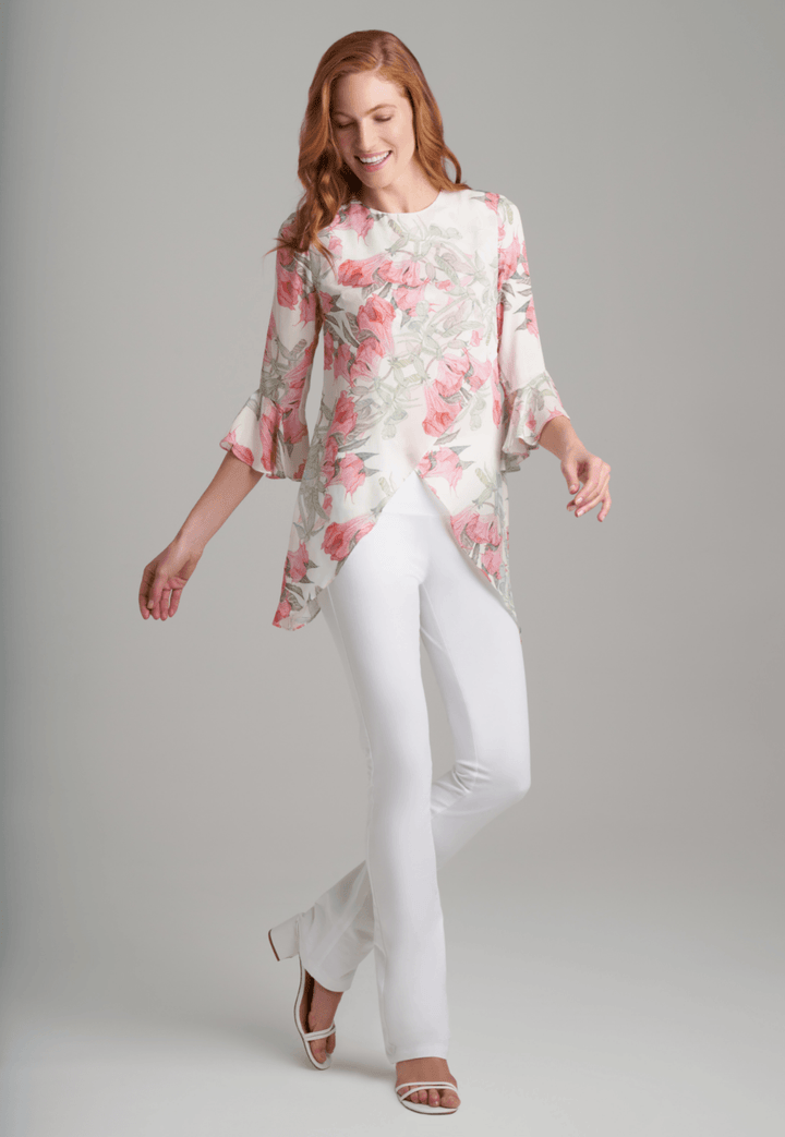 Woman wearing silk asymmetrical flower printed blouse with stretch knit white pants by Ala von Auersperg for spring summer 2022