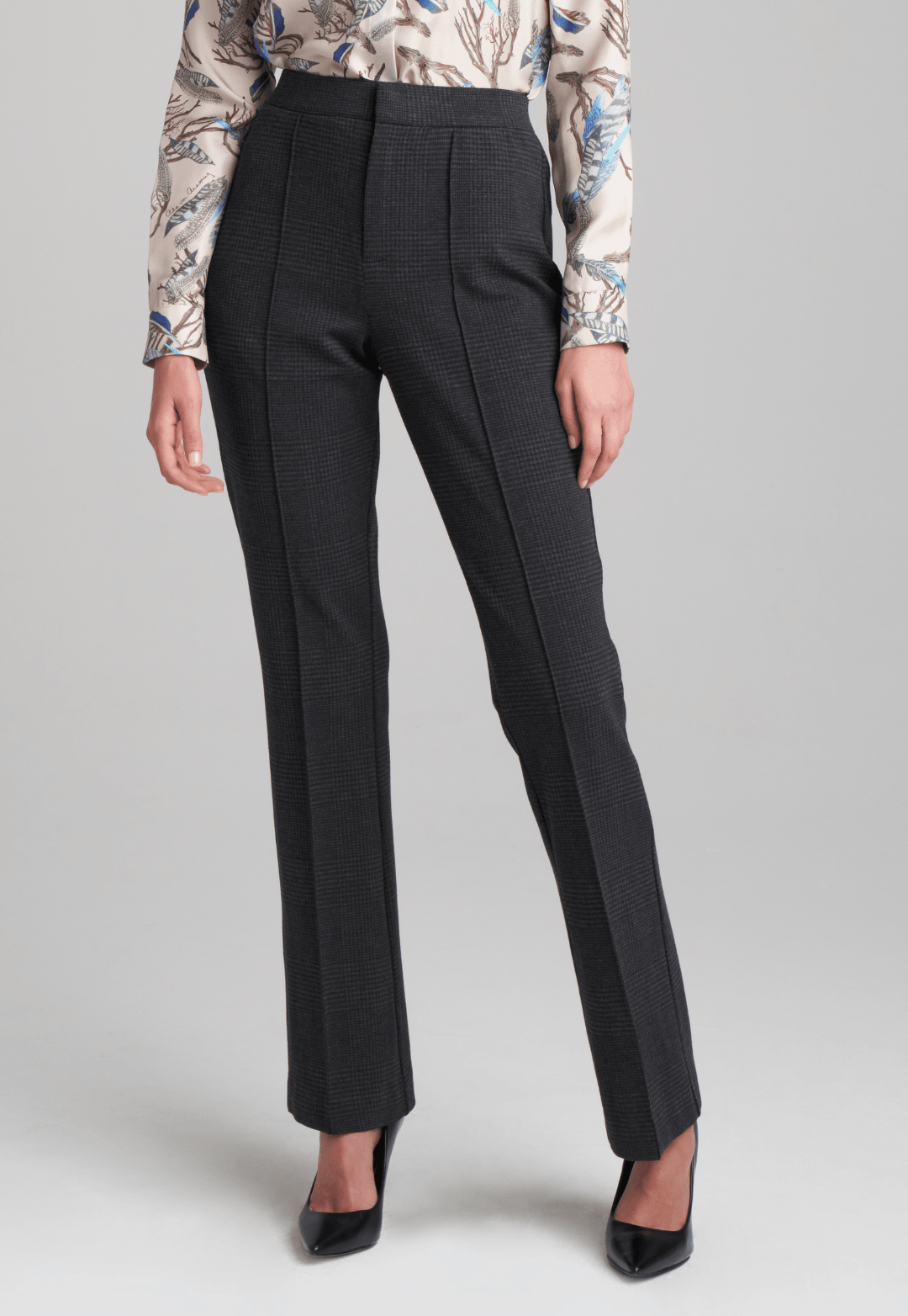 Woman wearing printed silk feather blouse with stretch knit plaid pants by Ala von Auersperg for fall 2022