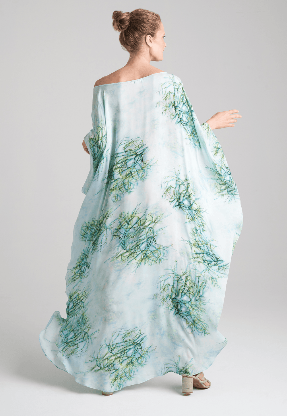 Woman wearing silk boat neck green printed kaftan by Ala von Auersperg