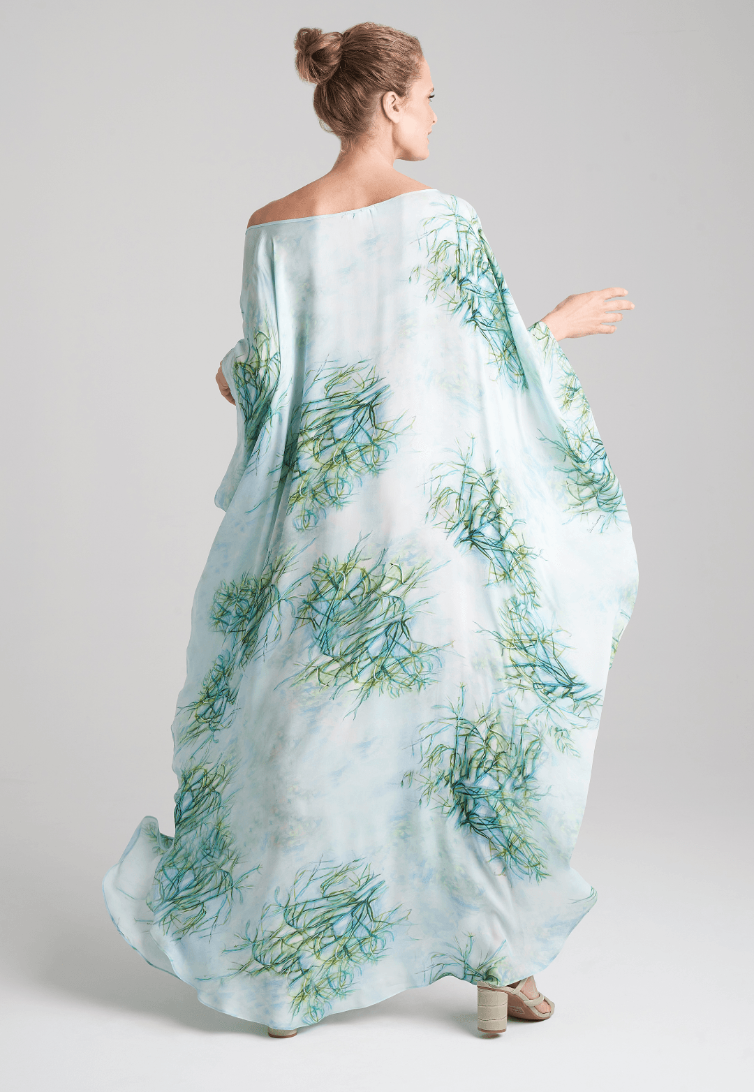 Woman wearing silk boat neck green printed kaftan by Ala von Auersperg