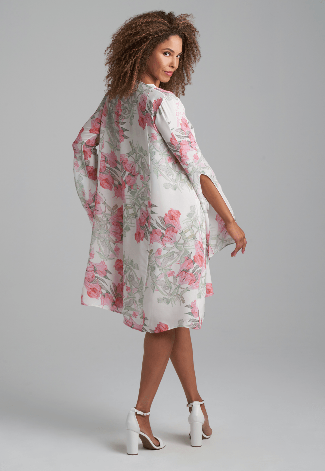Woman wearing short flower printed silk cocktail dress with long sleeves by Ala von Auersperg for spring summer 2022