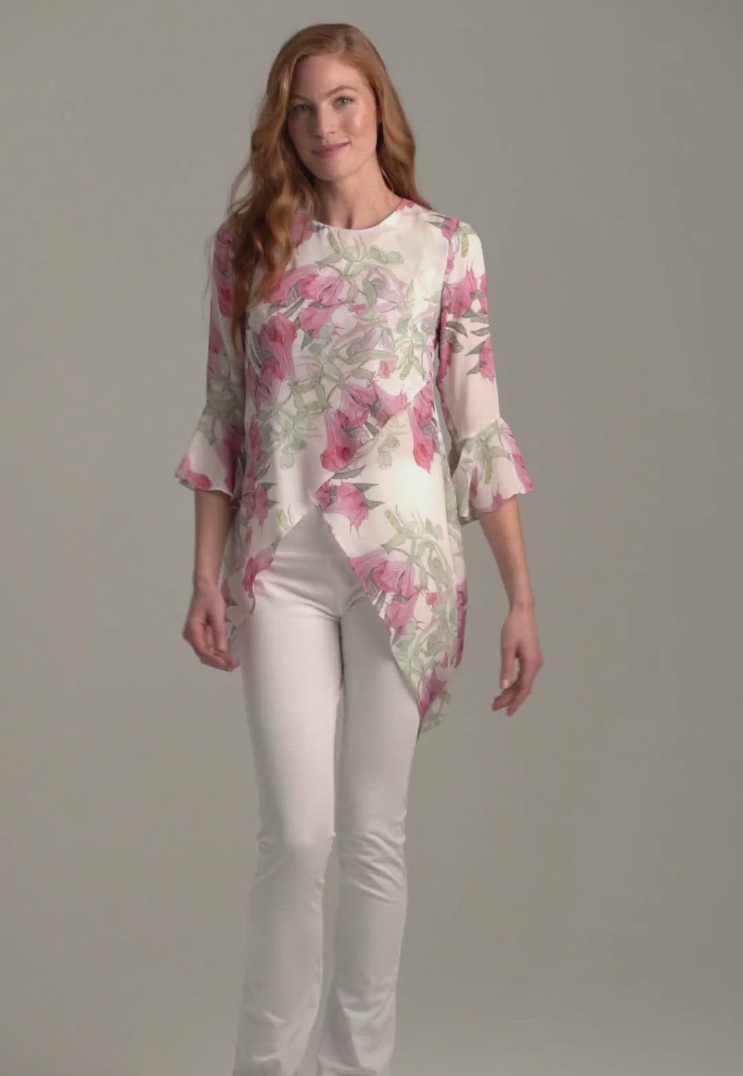 Woman wearing silk asymmetrical flower printed blouse with stretch knit white pants by Ala von Auersperg for spring summer 2022