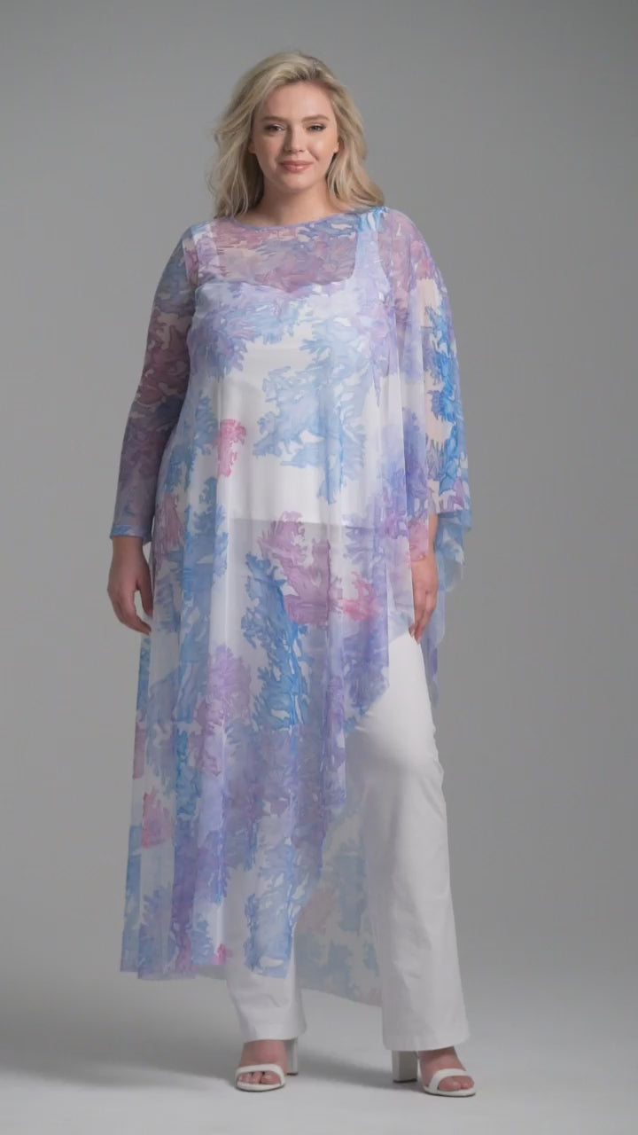 Woman wearing rainbow coral printed mesh one armed kaftan poncho over italian stretch cotton white tank top and pants by Ala von Auersperg for resort 2023
