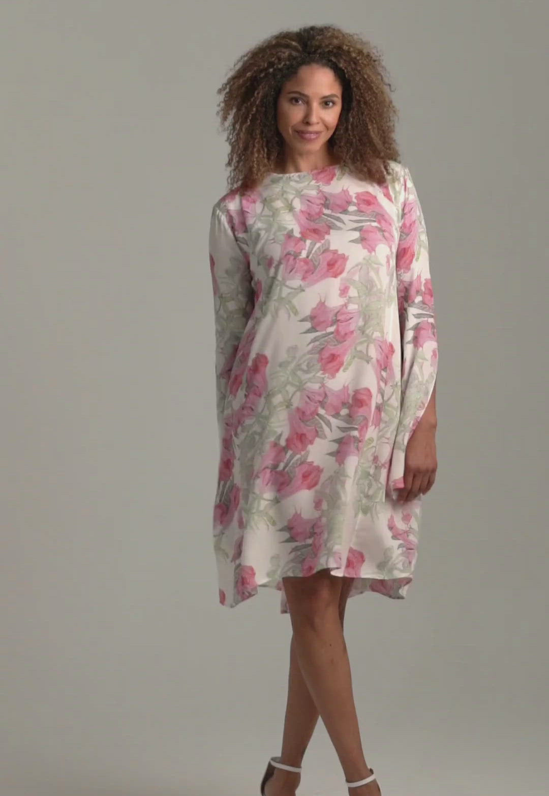 Woman wearing short flower printed silk cocktail dress with long sleeves by Ala von Auersperg for spring summer 2022