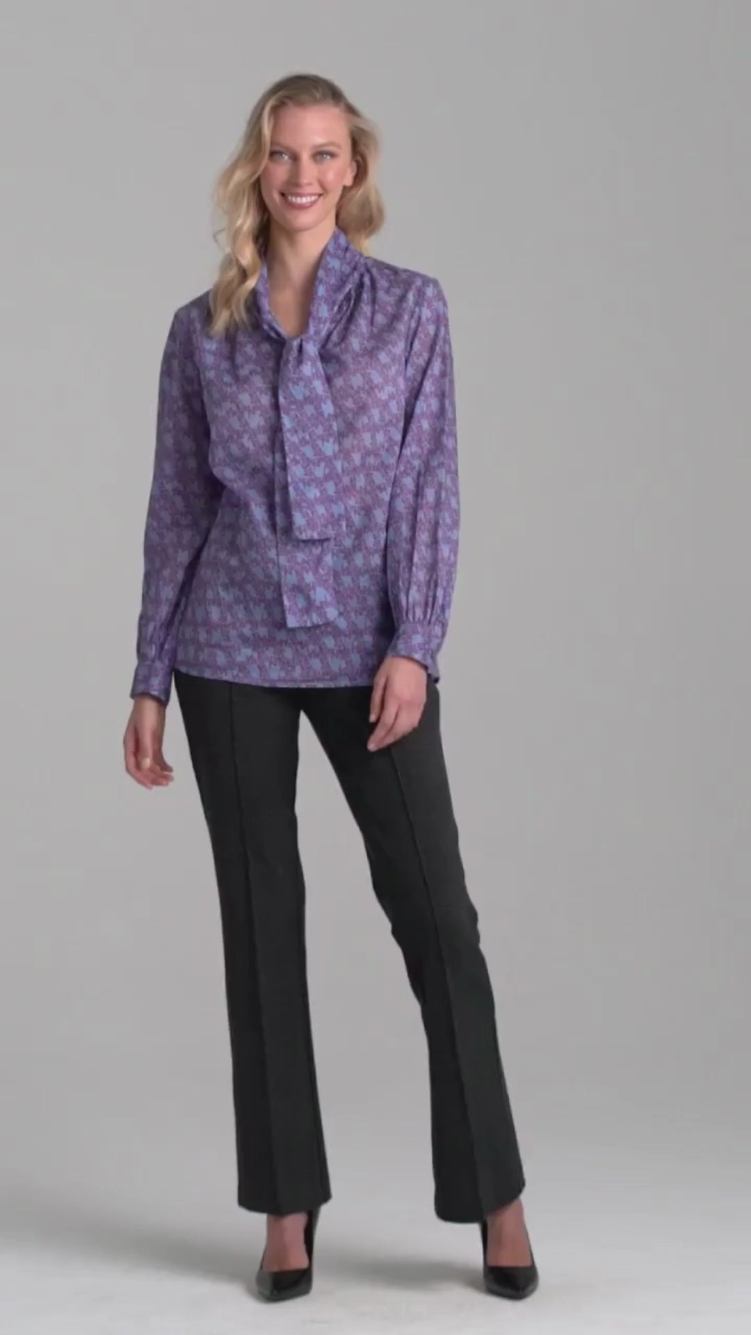 Woman wearing purple and blue bird printed cotton blouse and stretch knit plaid pants by Ala von Auersperg for fall 2022