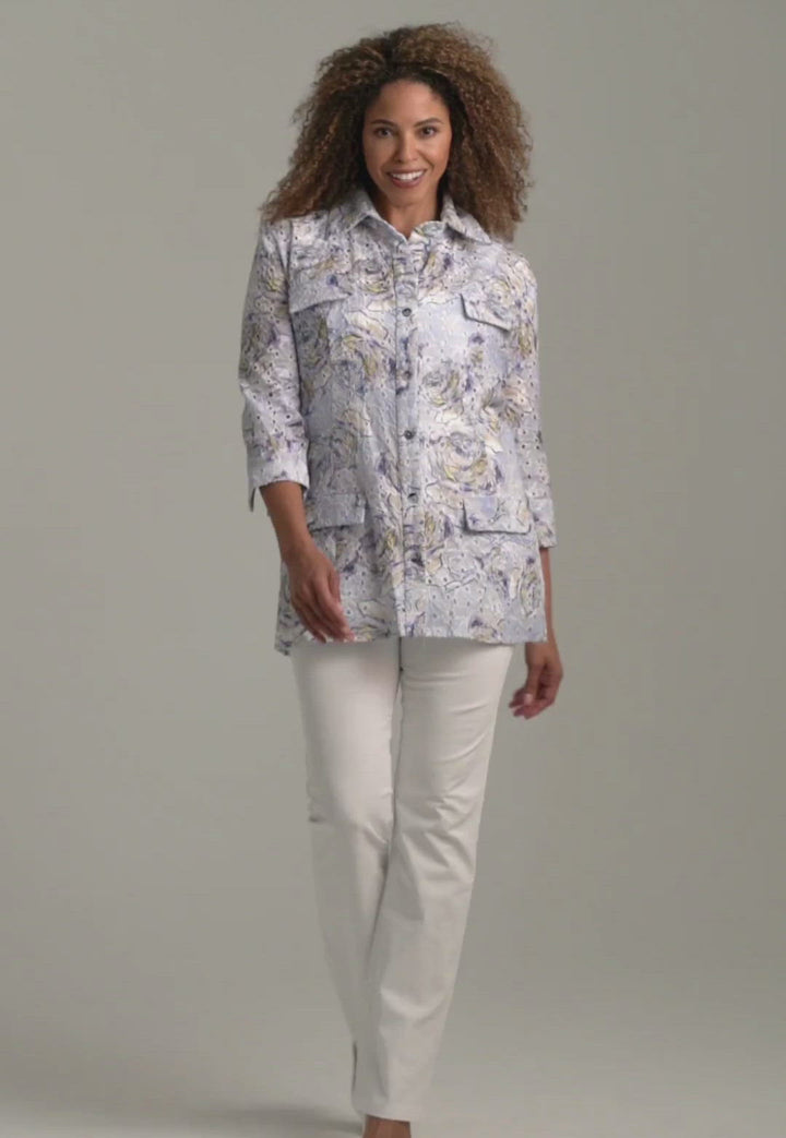 Woman wearing blue rose printed cotton eyelet safari shirt jacket with white stretch knit pants by Ala von Auersperg for spring summer 2022